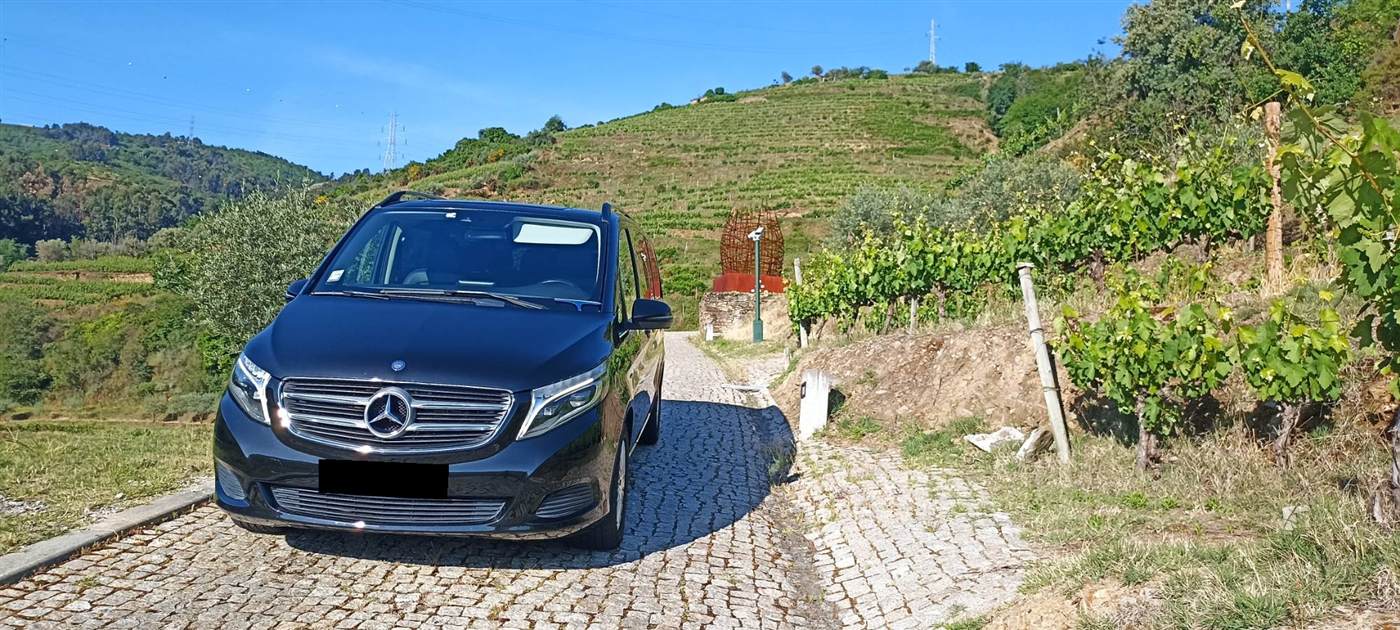Black Mercedes-Benz V-Class van on a cobbled road in the Douro vineyards
